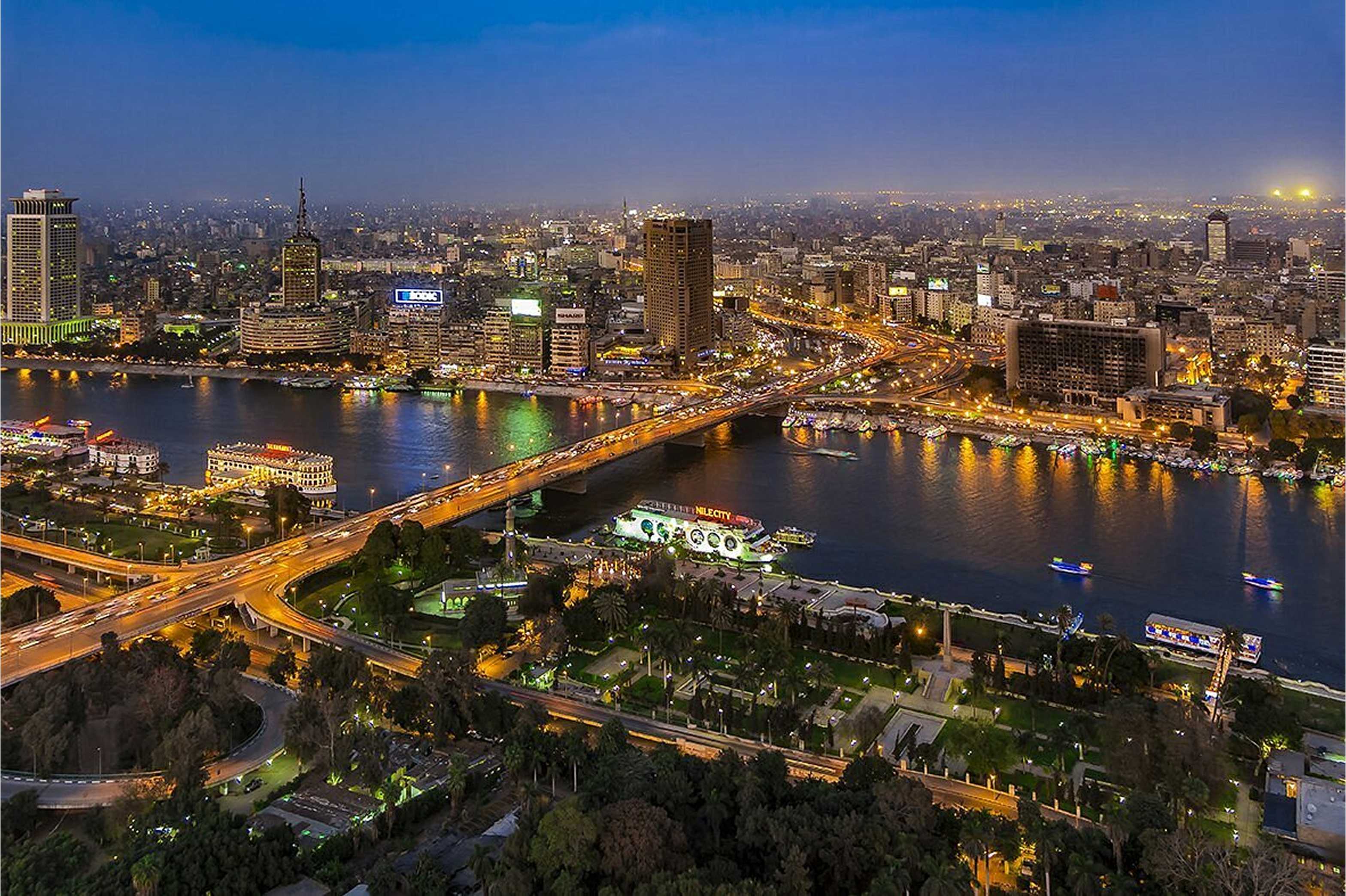 Breathtaking aerial view of Cairo at night with the illuminated Nile River, bridges, and cityscape