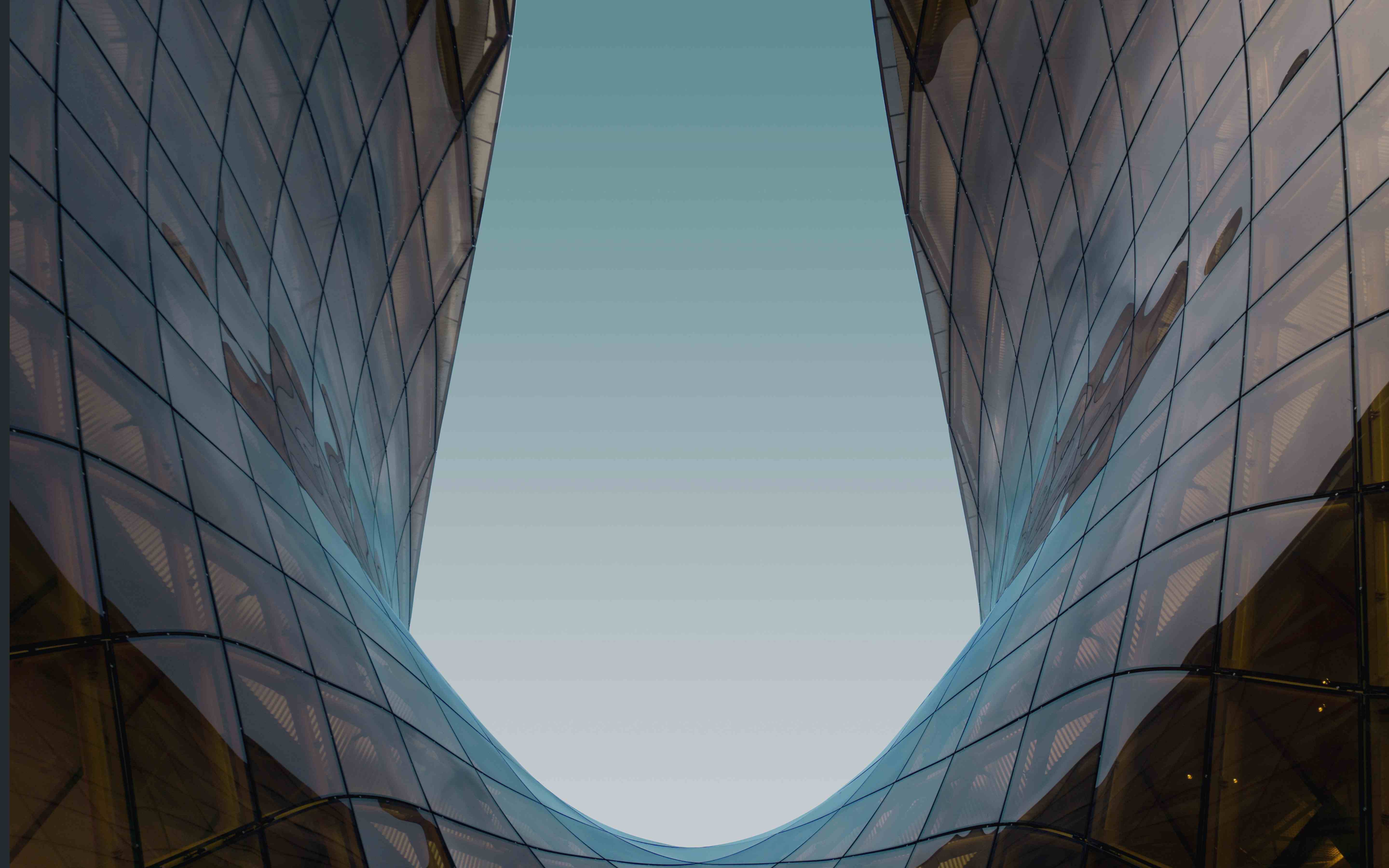 Modern glass buildings creating an upward perspective toward the sky - symbolizing vision and aspiration