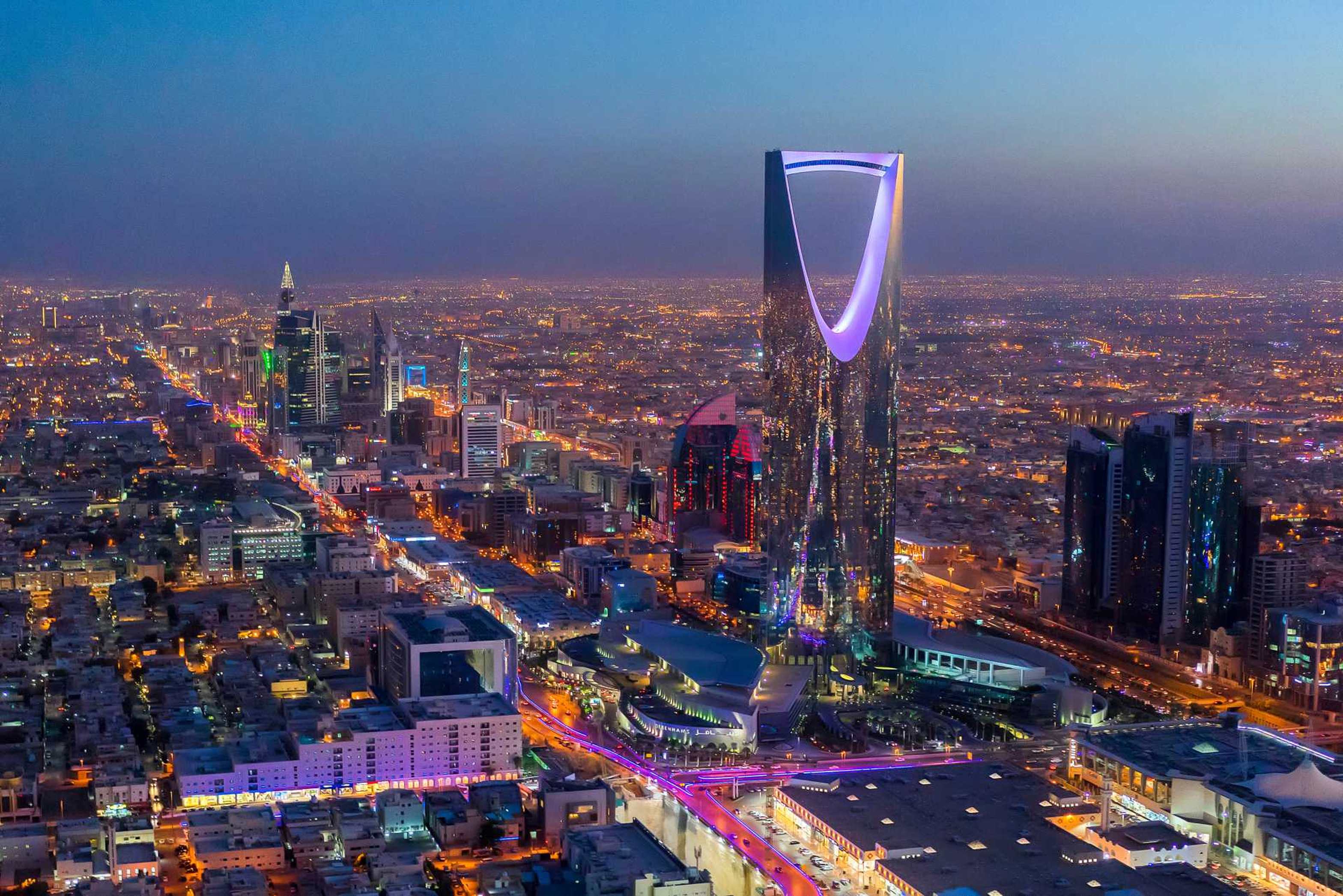 Stunning aerial view of Riyadh skyline at dusk featuring the iconic Kingdom Centre Tower and illuminated cityscape